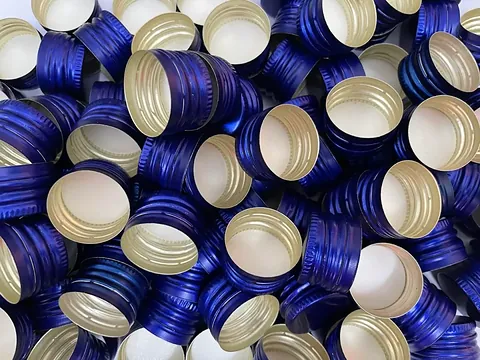 Blue colour-coated aluminium ROPP caps with gold interior lacquer by GSR Metal Caps