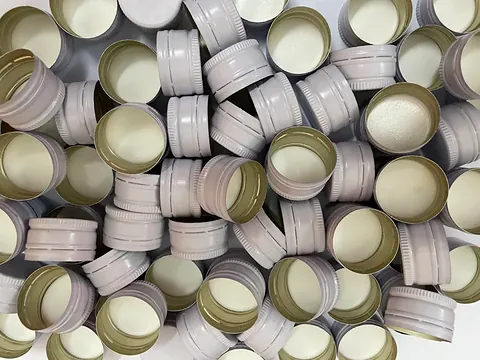 White and custom-colour aluminium pilfer-proof caps manufactured by GSR Metal Caps